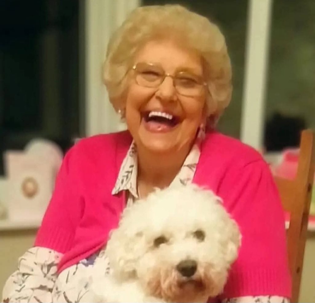 Jackie, Mathew Hulbert's mum, with a small white dog.